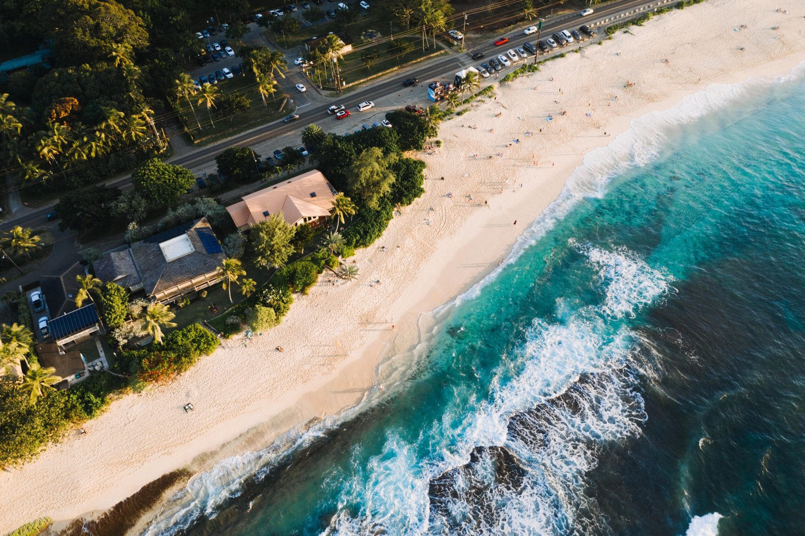 An aerial shot of houses and roads near the sandy beach